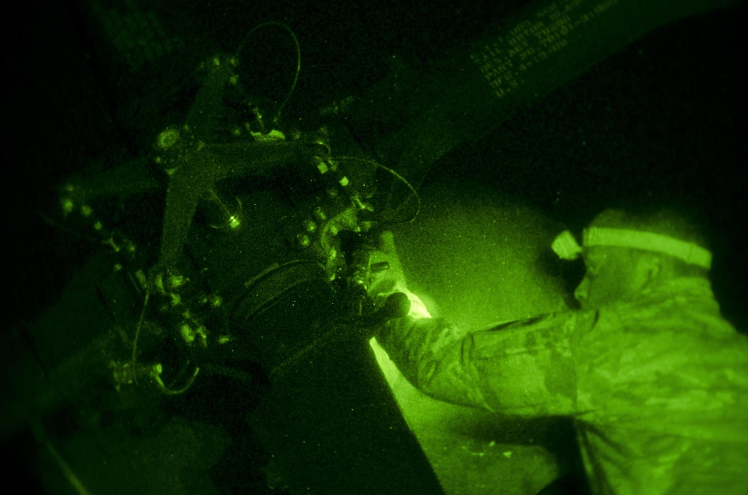 As seen through a night-vision device, U.S. Army Spc. Ronald Kelly conducts a post-flight inspection on a Black Hawk helicopter's tail rotor at Mihail Kogălniceanu Air Force Base, Romania, Dec. 9, 2015. Kelly is a crew chief assigned to the 1st Cavalry Division's 3rd Battalion, 227th Assault Helicopter Battalion, Air Cavalry Brigade. U.S. Army photo by Staff Sgt. Steven M. Colvin