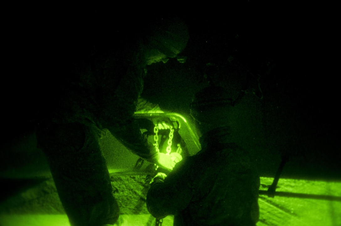 As seen through a night-vision device, soldiers secure a UH-60 Black Hawk helicopter to the helipad on Mihail Kogălniceanu Air Force Base, Romania, Dec. 9, 2015. U.S. Army photo by Staff Sgt. Steven M. Colvin