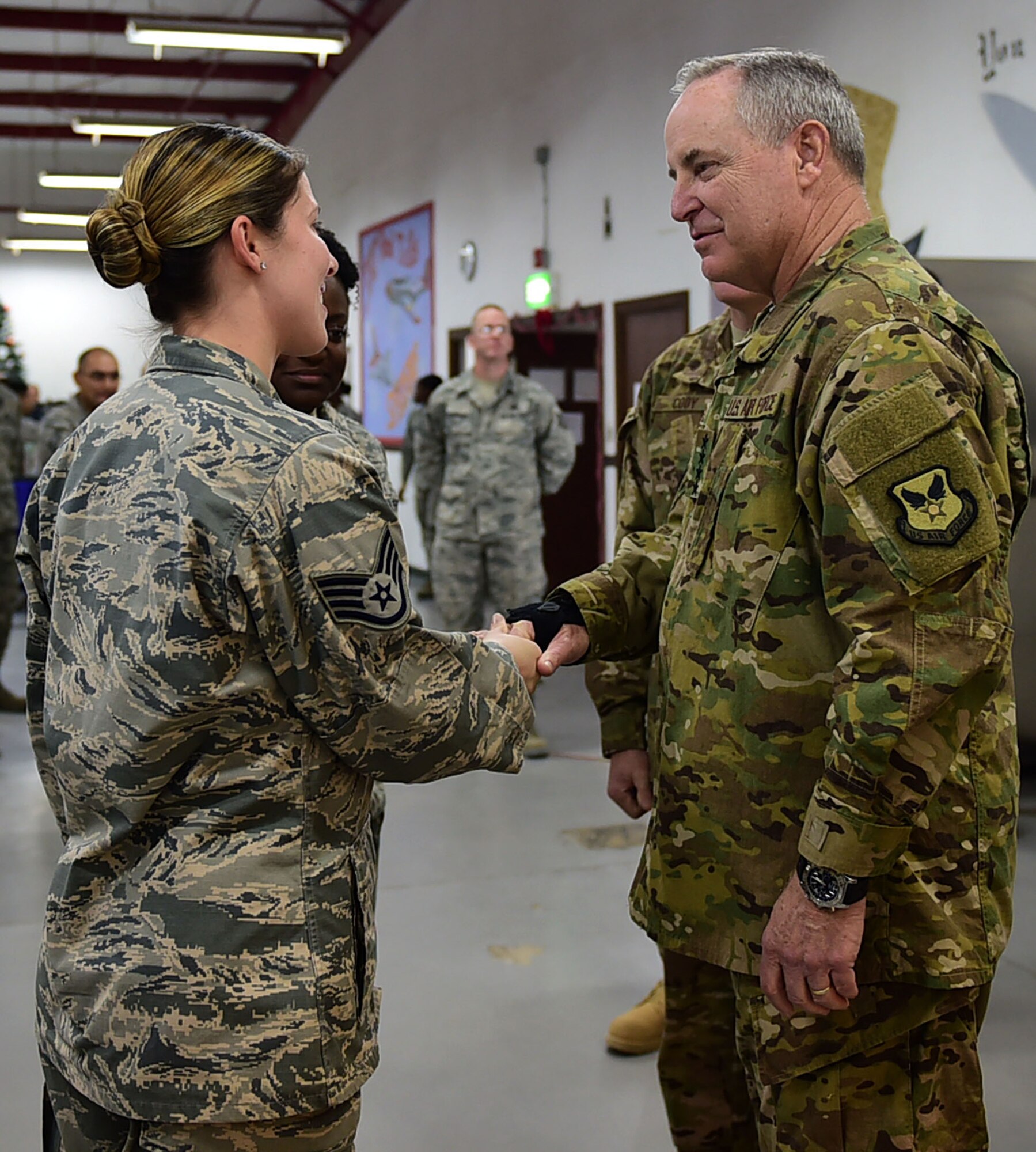 Air Force Chief of Staff Gen. Mark A. Welsh III coins Staff Sgt. Laura Estacion, 332nd Expeditionary Medical Group public health technician, during a visit to an undisclosed location in Southwest Asia, Dec. 10, 2015. Estacion was one of five outstanding performers from the 332nd AEW recognized for their contributions to the mission. (U.S. Air Force photo by Staff Sgt. Jerilyn Quintanilla)