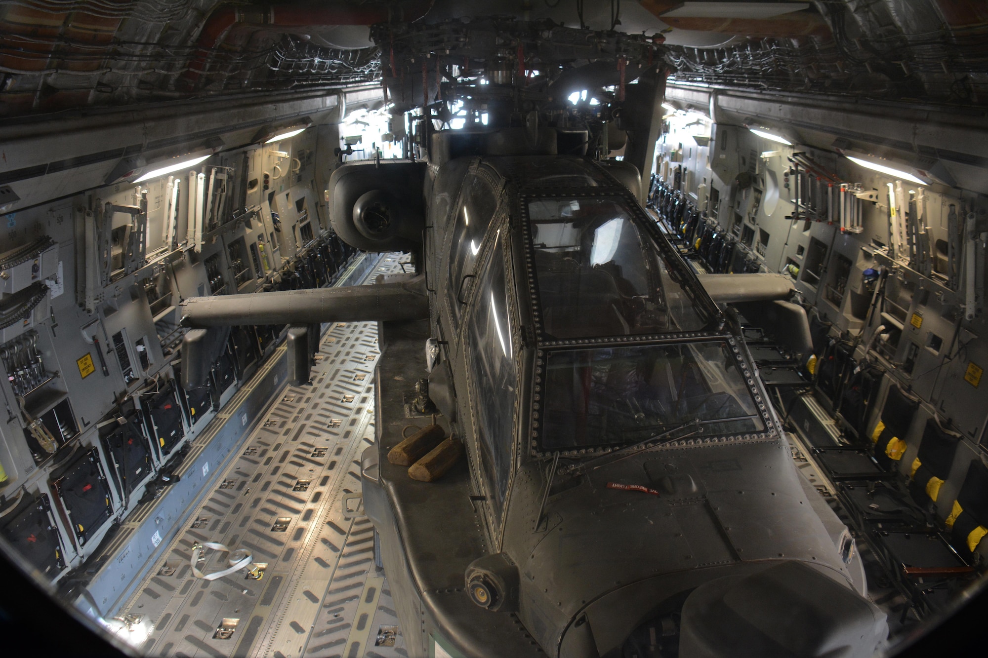 One of two Apache helicopters from Fort Bliss, Texas sits in the back of a C-17 Globemaster III at Al Udeid Air Base, Qatar Dec. 13. The C-17, which is deployed from the 62nd Airlift Wing at Joint Base Lewis-McChord, Washington, delivered the helicopters. The helicopters are scheduled to take part in the annual Qatar National Day Parade set for Dec. 18. (U.S. Air Force photo by Tech. Sgt. James Hodgman/Released)