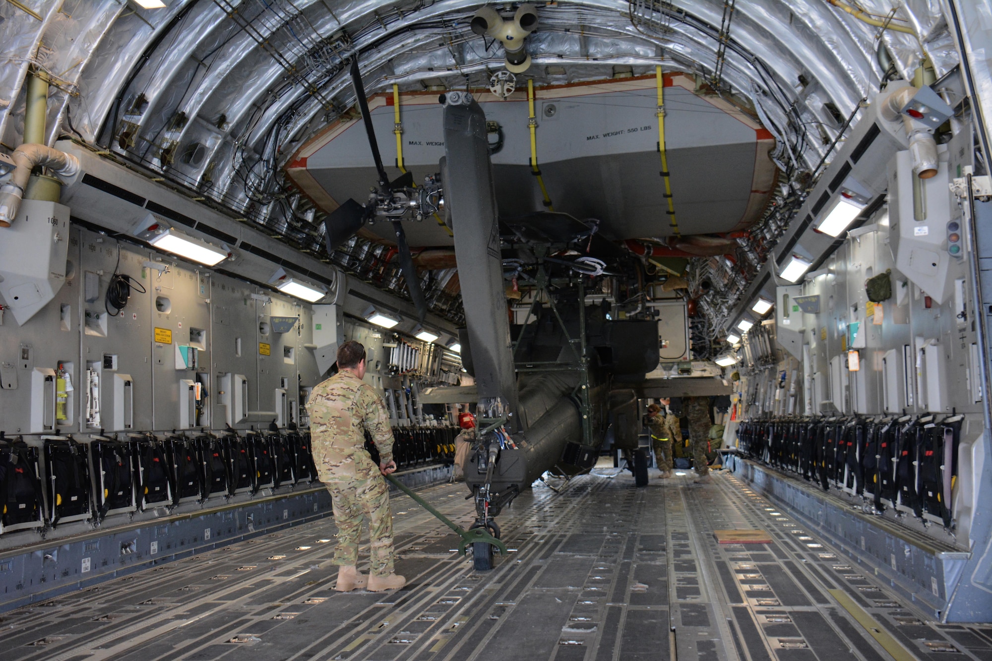 3-6 Heavy Cavalry Regiment soldiers deployed from Fort Bliss, Texas work to move one of two Apache helicopters out of a C-17 Globemaster III at Al Udeid Air Base, Qatar Dec. 13. The C-17, which is deployed from the 62nd Airlift Wing at Joint Base Lewis-McChord, Washington, delivered the helicopters. The helicopters are scheduled to take part in the annual Qatar National Day Parade set for Dec. 18. (U.S. Air Force photo by Tech. Sgt. James Hodgman/Released)