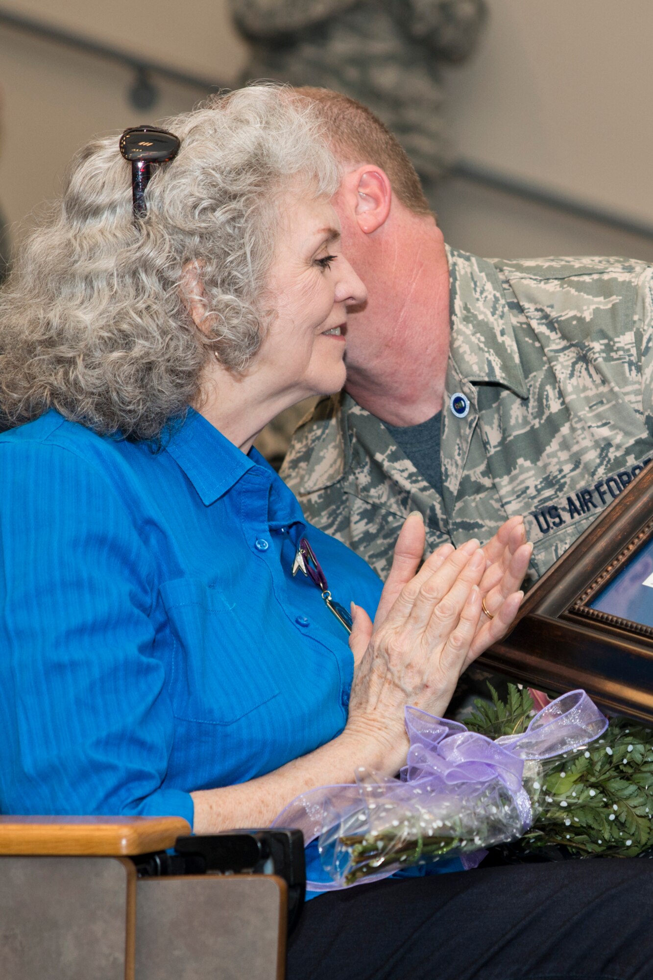 U.S. Air Force Retired Master Sgt. Michael Ward kisses Betty, his wife of 26 years, after presenting her with flowers and a gift during his retirement ceremony at Little Rock Air Force Base, Ark., Dec. 11, 2015. Ward and Betty plan to move back to West Virginia to begin the next chapter of their life together. (U.S. Air Force photo by Master Sgt. Jeff Walston/Released)     