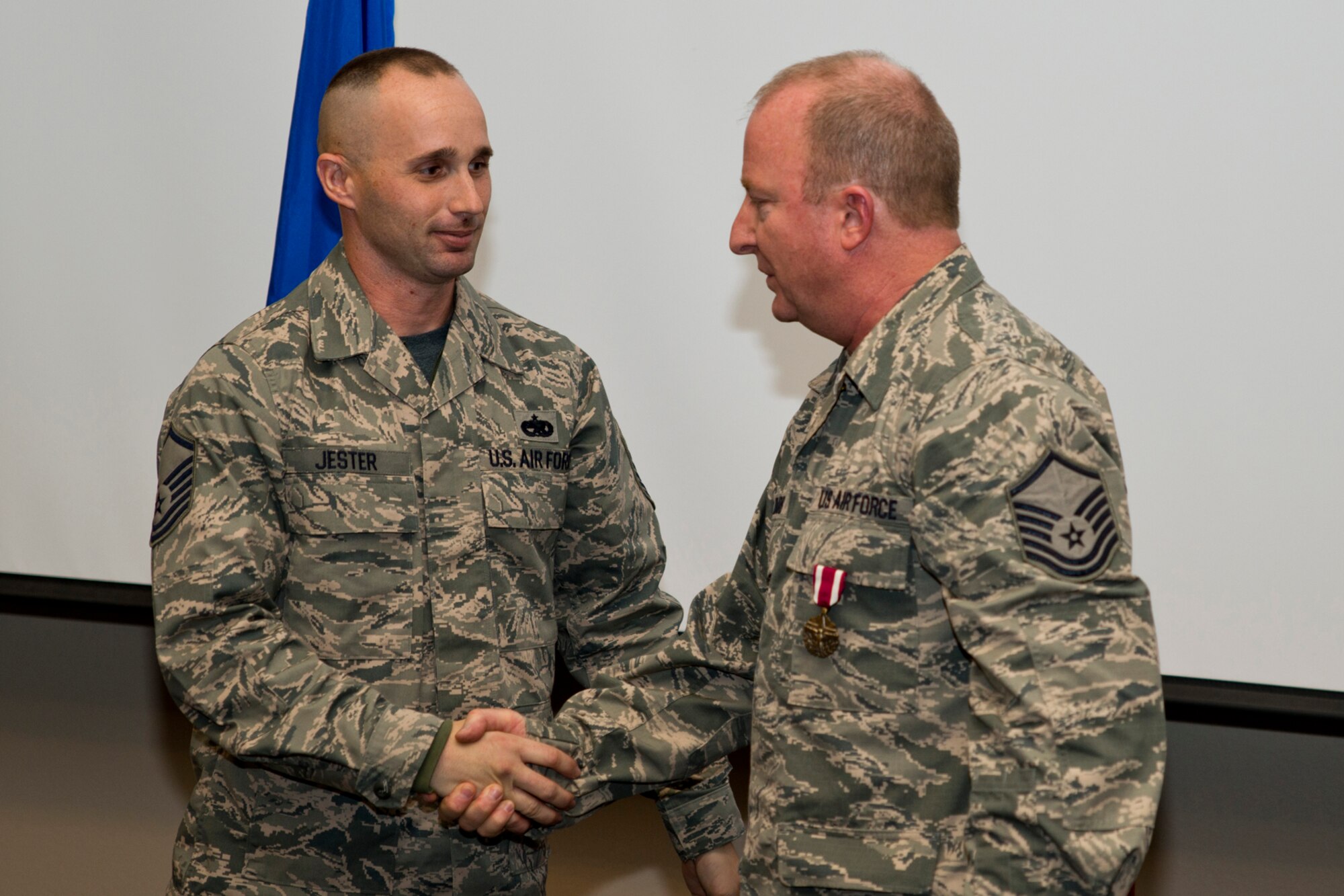 U.S. Air Force Master Sgt. Michael Jester, fabrication flight chief, 913th Maintenance Squadron, congratulates Retired Master Sgt. Michael Ward on his retirement at Ward’s retirement ceremony on Little Rock Air Force Base, Ark., Dec. 11, 2015. Ward retired after 32 years of military service in both the Air Force and Army National Guard. (U.S. Air Force photo by Master Sgt. Jeff Walston/Released)     