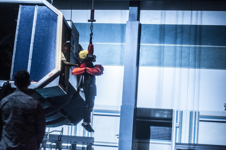 A Water Survival student gets hoisted back into a training fuselage by a Survival, Evasion, Resistance and Escape instructor during a training scenario Dec. 8, 2015, at Fairchild Air Force Base, Wash. Course capacity is capped at 34 students and is primarily made up of flight crew members and battlefield Airmen, but can also include members from other career fields and each branch of service. (U.S. Air Force photo/Airman 1st Class Sean Campbell)