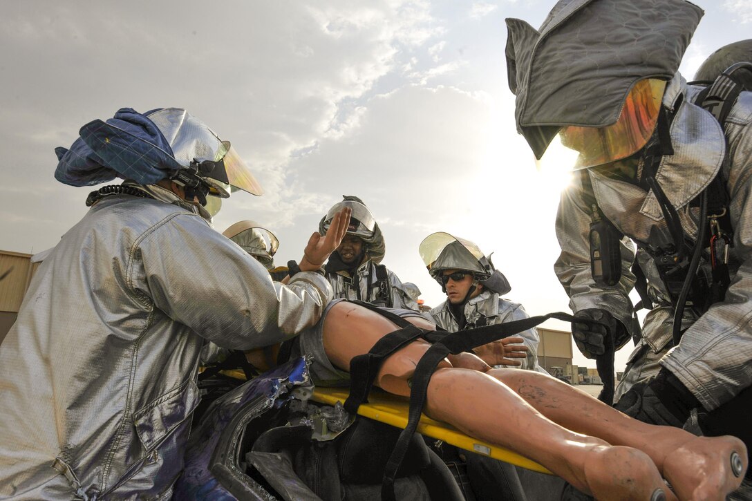 U.S. Air Force firefighters pull a simulated patient from a vehicle during a mass casualty exercise on Al Udeid Air Base, Qatar, Dec. 15, 2015. The firefighters are assigned to the 379th Air Expeditionary Civil Engineer Squadron. U.S. Air Force photo by Master Sgt. Joshua Strang