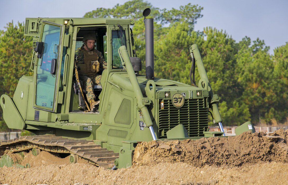 Lance Cpl. Taylor Woolman, a heavy equipment operator with Combat Logistics Battalion 6, 2nd Marine Logistics Group begins to create a five-foot deep tank ditch with the Medium Crawler Tractor during a development of a simulated Forward Operating Base exercise at Camp Lejeune, N.C. Dec. 8, 2015. A tank ditch’s purpose is to expose the bottom of the tank, where it is the weakest, which provides an opening to neutralize the tank. The operators within the unit prepare for future operations by conducting training parallel to what they would be doing in a deployed environment. (U.S. Marine Corps photo by Lance Cpl. Luke J. Hoogendam/Released)