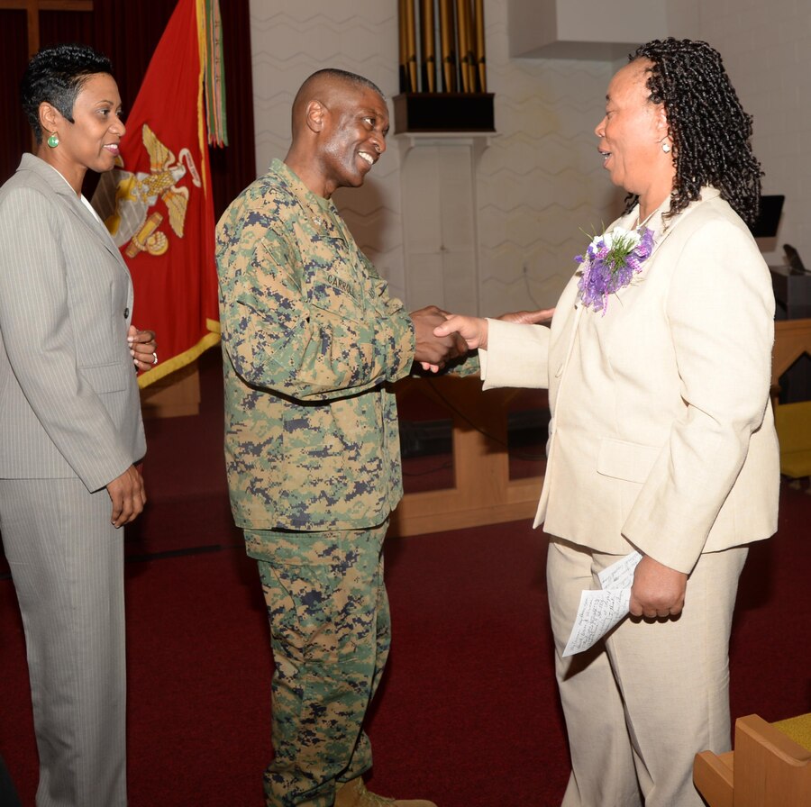 Col. James C. Carroll III, commanding officer, Marine Corps Logistics Base Albany, congratulates Virginia Williams, IT supervisor, MCLB Albany, during her retirement ceremony, Dec. 10, in the base’s Chapel of the Good Shepherd.