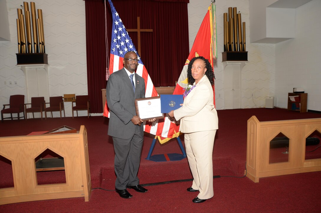 Virginia Williams, IT supervisor, Marine Corps Logistics Base Albany, receives a letter of commendation from Kenneth J. Cutts on behalf of Congressman Sanford D. Bishop Jr., Dec. 10, during her retirement ceremony in the base’s Chapel of the Good Shepherd. 