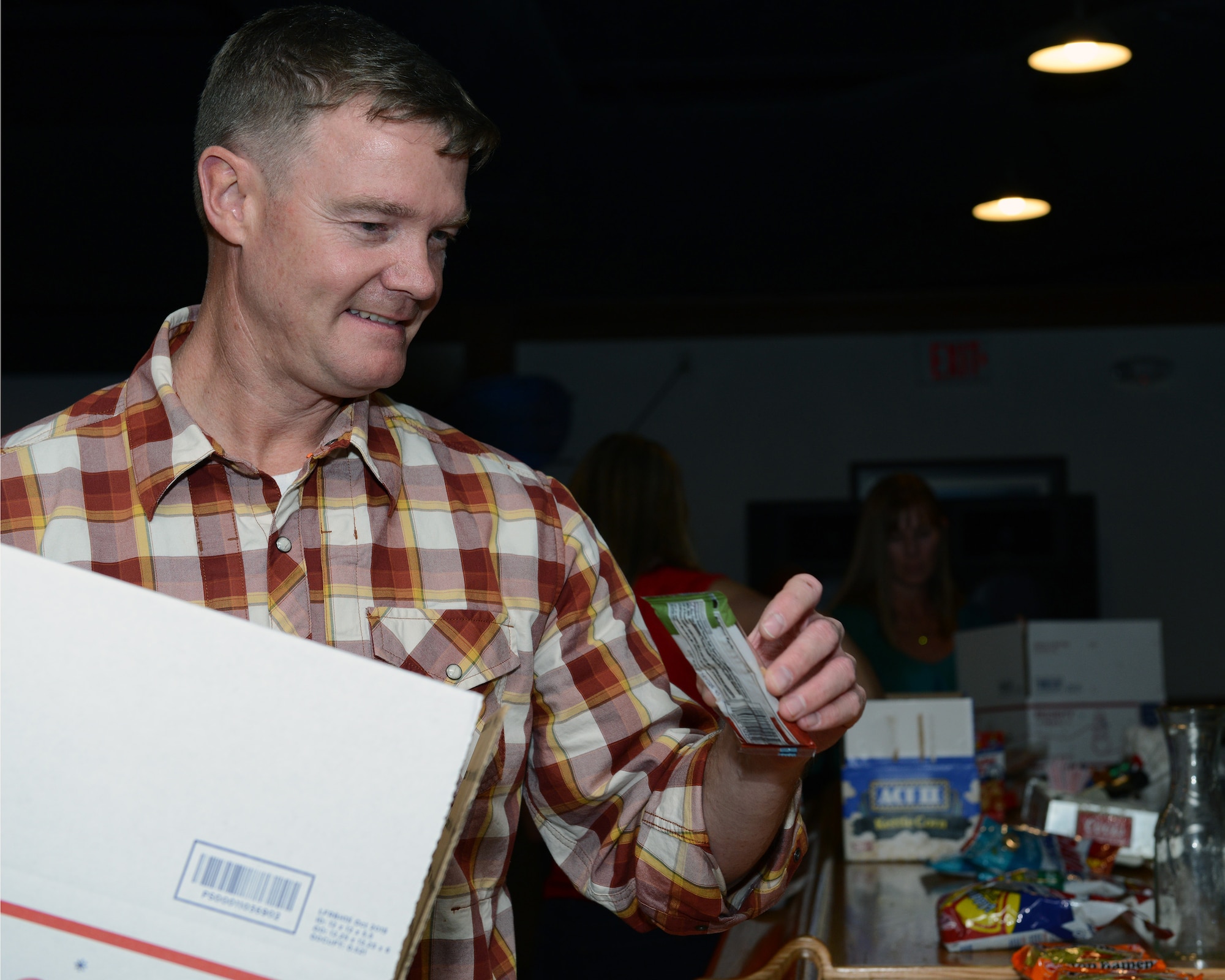 Col. Thomas Shank, 47th Flying Training Wing commander, fills a box with snacks and hygiene items at Laughlin Air Force Base, Texas, Dec. 10, 2015. Thirteen packages were put together to support “Operation Spoil the Deployer” to raise morale of Laughlin’s deployed service members. (U.S. Air Force photo by Senior Airman Jimmie D. Pike)