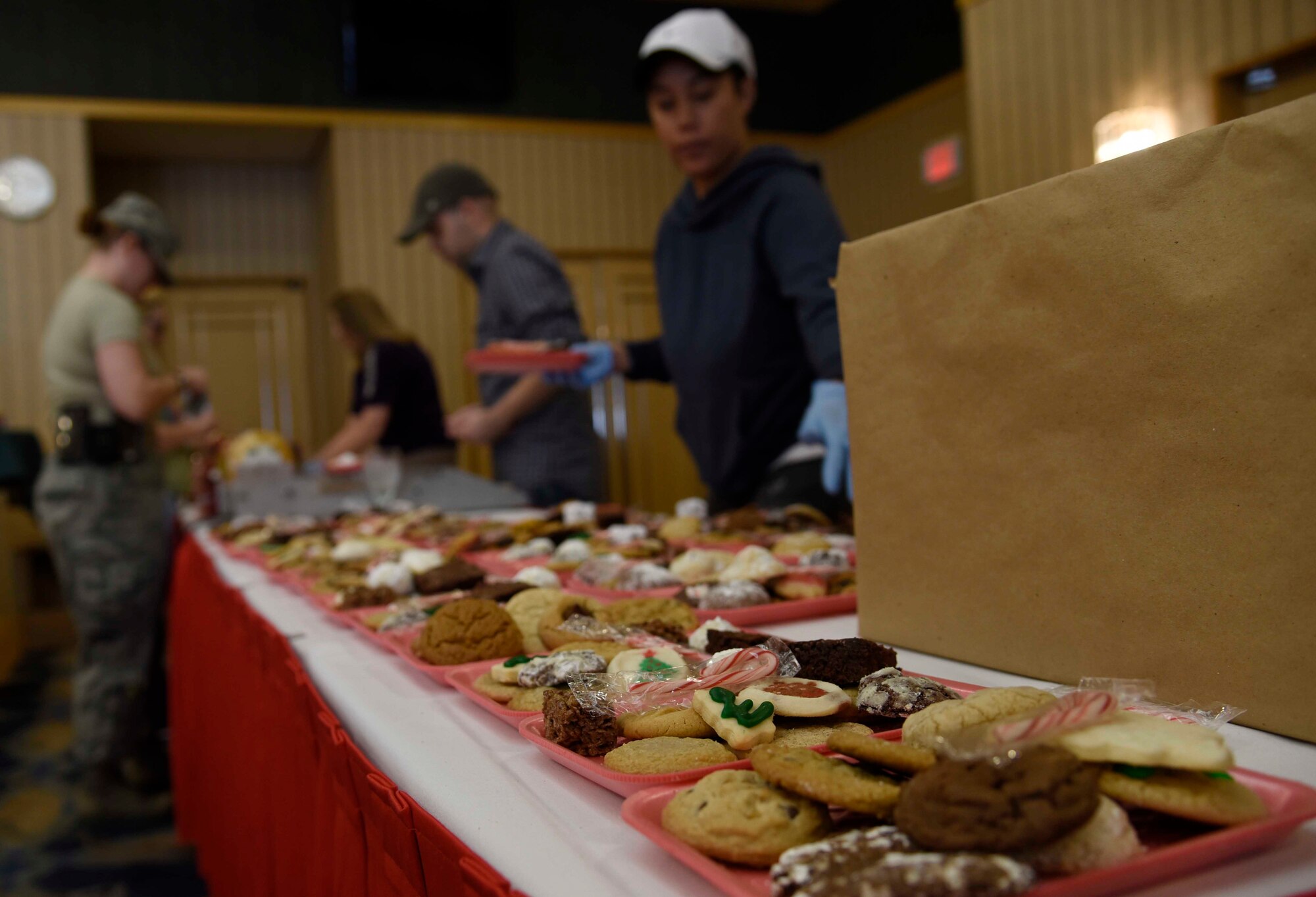Volunteers wrap trays of cookies at Misawa Air Base, Japan, Dec. 9, 2015. Misawa community members donated cookie dough and home-baked cookies, which were then organized into trays at the Mutsu Officers’ Club for the annual Cookie Caper. (U.S. Air Force photo by Airman 1st Class Jordyn Fetter/Released)