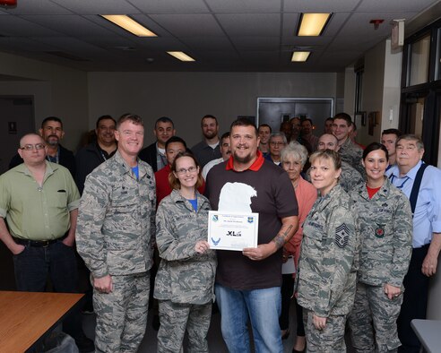 Justin Westbrook, center-right, 47th Civil Engineer Squadron Information Technology specialist, and his wife, Tech. Sgt. Westbrook, center-left, 47th Flying Training Wing commander support staff, pose with Col. Thomas Shank, left, 47th FTW commander, and Chief Master Sgt. Teresa Clapper, 47th FTW command chief, after accepting the “XLer of the Week” award, here, Dec. 11, 2015. The XLer is a weekly award chosen by wing leadership and is presented to those who consistently make outstanding contributions to their unit and Laughlin. (U.S. Air Force photo by Senior Airman Jimmie D. Pike)