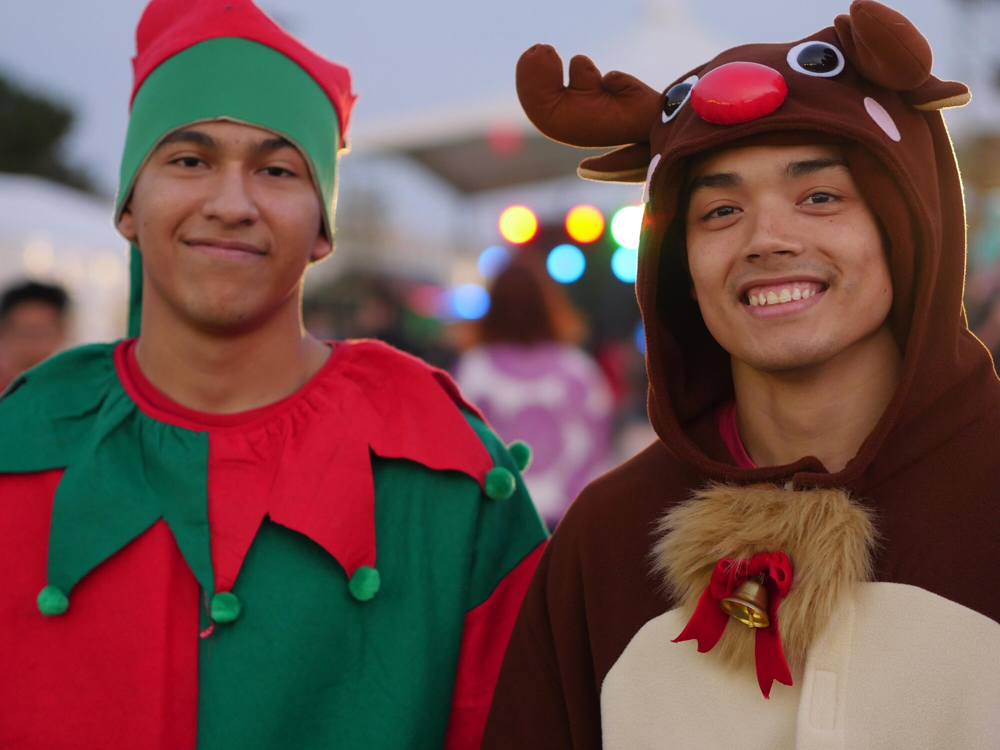 Airman 1st Class Barry Fernandez and Senior Airman Cuong Pham, 18th Logistics Readiness Squadron vehicle operators, dress as an elf and reindeer Dec. 12, 2015 at Tinsel Town at Kadena Air Base, Japan. Volunteers from Kadena dressed as holiday icons to greet children and their families during Tinsel Town. (U.S. Air Force photo by Senior Airman Omari Bernard)