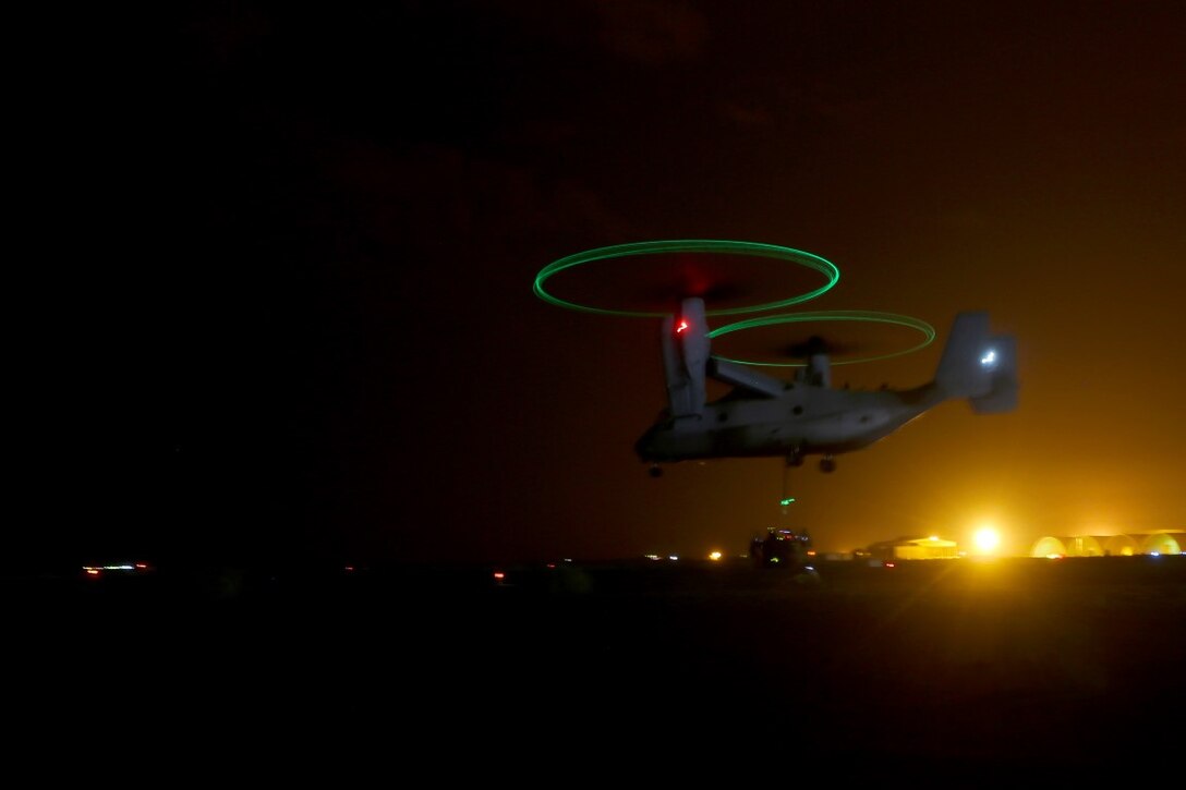 A U.S. Marine Corps MV-22B Osprey with Marine Medium Tiltrotor Squadron 268, Special Purpose Marine Air Ground Task Force—Crisis Response—Central Command (SPMAGTF), hovers above the U.S. Marine helicopter support team with Combat Logistics Battalion 1, SPMAGTF-CR-CC, while the team attaches a load of cargo to the belly of the aircraft at an undisclosed location in Southwest Asia, Dec. 13, 2015. The squadron conducted the training in order to ensure its pilots are qualified to perform external loads to support the operational requirement of units operating within the U.S. Central Command’s area of responsibility. (Marine Corps photo by Sgt. Owen Kimbrel/RELEASED)