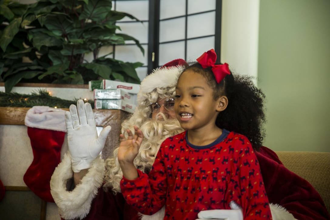 Santa Claus listens to what children want for Christmas during the event, Santa’s Little Helper, on Camp Hansen, Okinawa, Japan, Dec. 12, 2015. The event also had Santa fast rope out of a helicopter, fake snow, a bouncy castle, face painting and food served. The event was hosted by Combat Assault Battalion, 3rd Marine Division, III Marine Expeditionary Force and Marine Corps Community Services. (U.S. Marine Corps photo by Cpl. Tyler S. Giguere/Released)