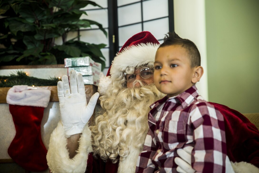 Santa Claus listens to what children want for Christmas during the event, Santa’s Little Helper, on Camp Hansen, Okinawa, Japan, Dec. 12, 2015. The event also had Santa fast rope out of a helicopter, fake snow, a bouncy castle, face painting and food served. The event was hosted by Combat Assault Battalion, 3rd Marine Division, III Marine Expeditionary Force and Marine Corps Community Services. (U.S. Marine Corps photo by Cpl. Tyler S. Giguere/Released)