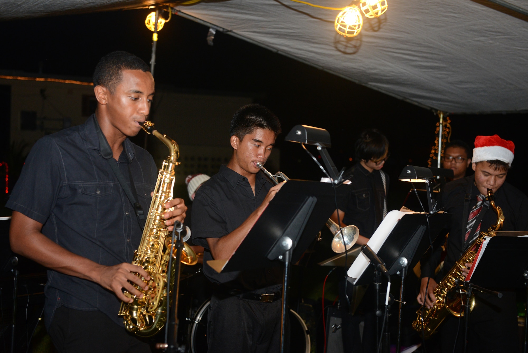 Members of the Guam High School Jazz Ensemble play holiday music for Team Andersen during the annual Rota Walk Dec 12, 2015, at Andersen Air Force Base, Guam. Hundreds of military members and civilians attended the event, which is held every December to showcase holiday decorations in the base housing area on Rota Drive. (U.S. Air Force photo/Airman 1st Class Arielle Vasquez)