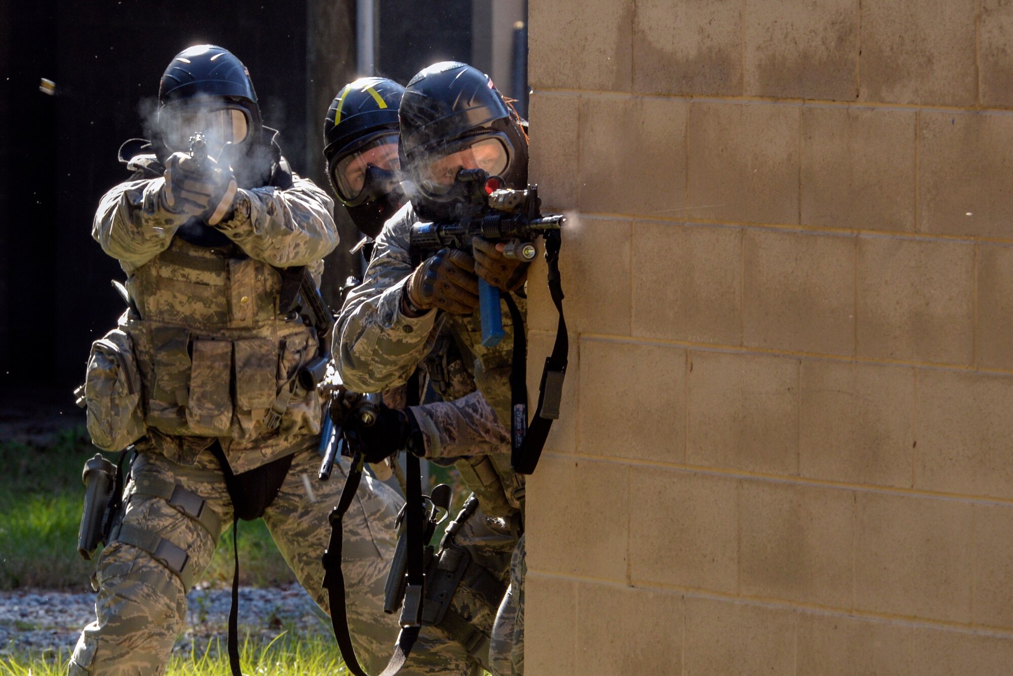Airmen from the 822d Base Defense Squadron return fire during a force-on-force training exercise at the military operations in urban terrain village, Dec. 10, 2015, at Moody Air Force Base, Ga. Airmen were divided into two teams with a  mission to recover and protect a casualty while opposing forces attempted to stop them. (U.S. Air Force photo by Airman 1st Class Janiqua P. Robinson/Released)