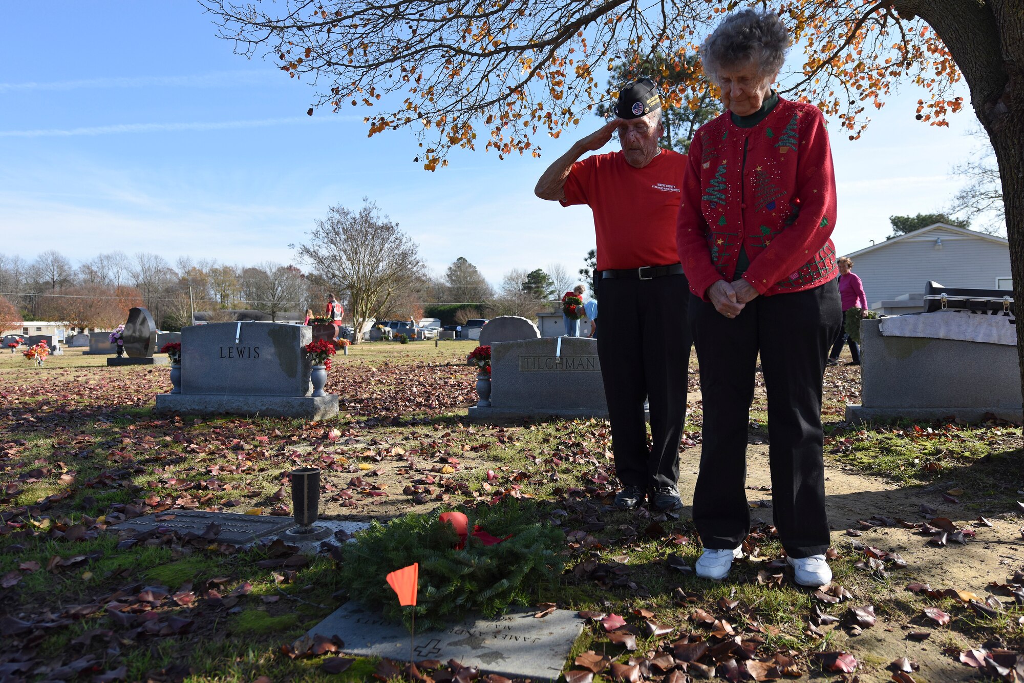 Retired Navy Master Chief Petty Officer Gerry Phelps salutes the grave of a friend and former military member while his wife Jeanne Phelps joins him in paying respect at a Wreaths Across America Event, Dec. 12, 2015, at the Evergreen Memorial Cemetery in Princeton, North Carolina . The Phelps family joined more than 100 volunteers for the local event, while people across the nation attended similar ceremonies. (U.S. Air Force photo/Senior Airman Aaron J. Jenne)
