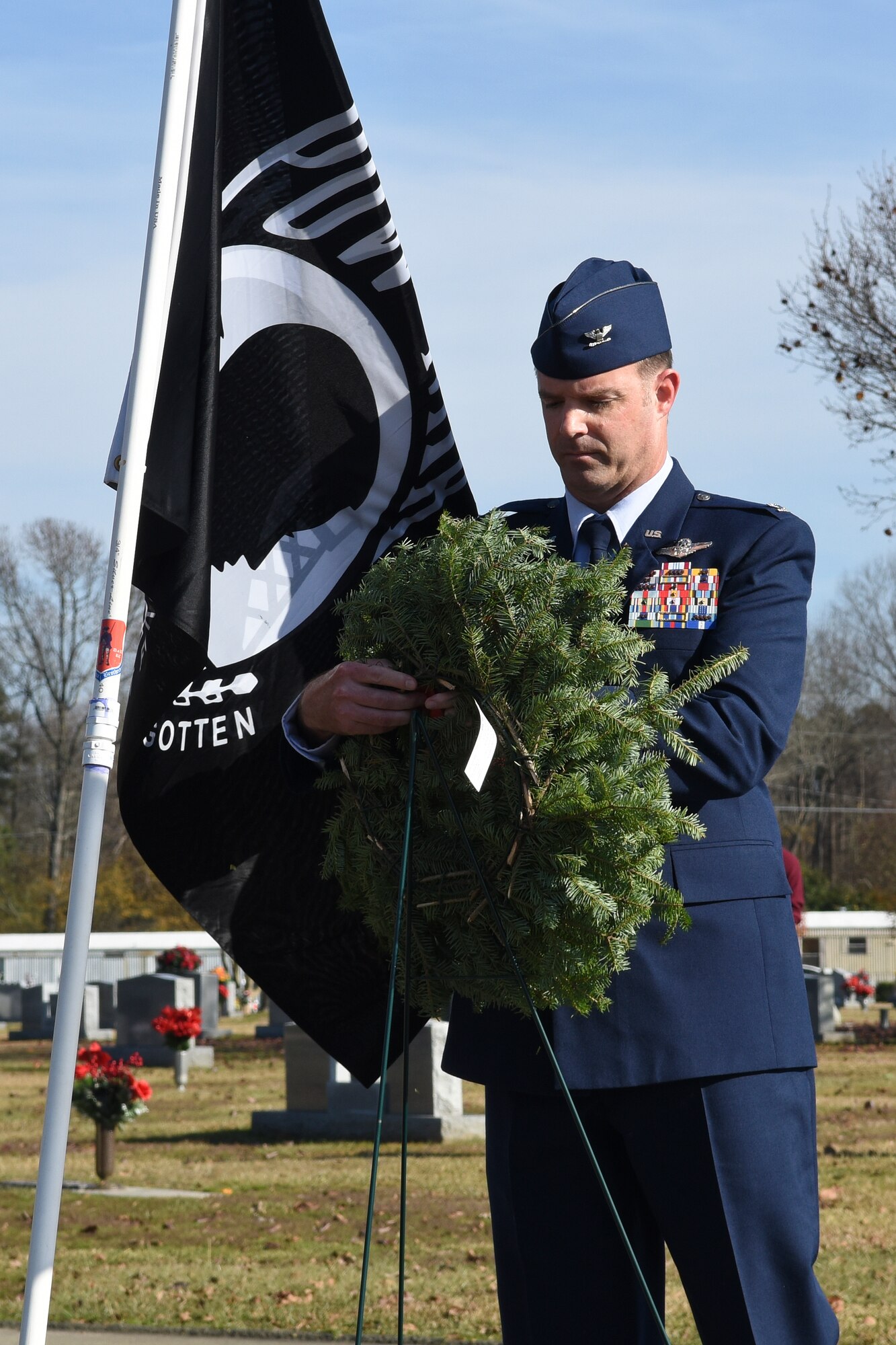 Col. Andrew Bernard, 4th Fighter Wing vice commander, places a ceremonial wreath by the Prisoner of War, Missing in Action flag, Dec. 12, 2015, at the Evergreen Memorial Cemetery in Princeton, North Carolina. Bernard hung the wreath to honor all former service members who were previously prisoners of war or missing in action. (U.S. Air Force photo/Senior Airman Aaron J. Jenne)