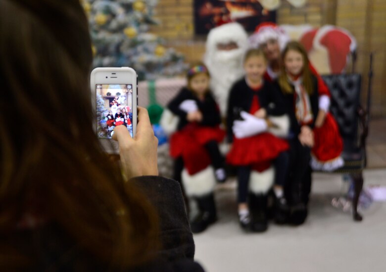 From left to right, Aspen, 3, Ariana, 6, and Alice, 9, sit on Santa's lap while their mother takes a photo during the third annual Children's Holiday Party Dec. 12, 2015, at Creech Air Force Base, Nevada. The party included activities such as arts and crafts, bouncy houses, toys for smiles, information booths, selfie stations, vehicle static displays, free food, games, and photos with Santa. (U.S. Air Force photo by Airman 1st Class Christian Clausen/Released)