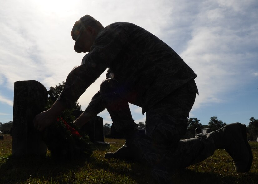 Capt. David Marble, 325th Fighter Wing wing plans deputy chief, lays a wreath across a grave during the Wreaths Across America ceremony at Mount Hope Cemetery, Lynn Haven, Fla. Dec. 12. Wreaths Across America is officially recognized on Dec 13. (U.S. Air Force photo by Senior Airman Ty-Rico Lea/Released)