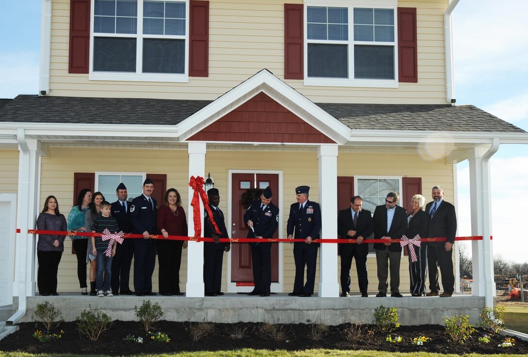 Members of Team McConnell and Corvias Military Living cut a ceremonial ribbon, Dec. 11, 2015, at McConnell Air Force Base, Kan. The event recognized the completion of four new homes in the Corvias Military Living new base-housing project. (U.S. Air Force photo/Airman Jenna K. Caldwell)