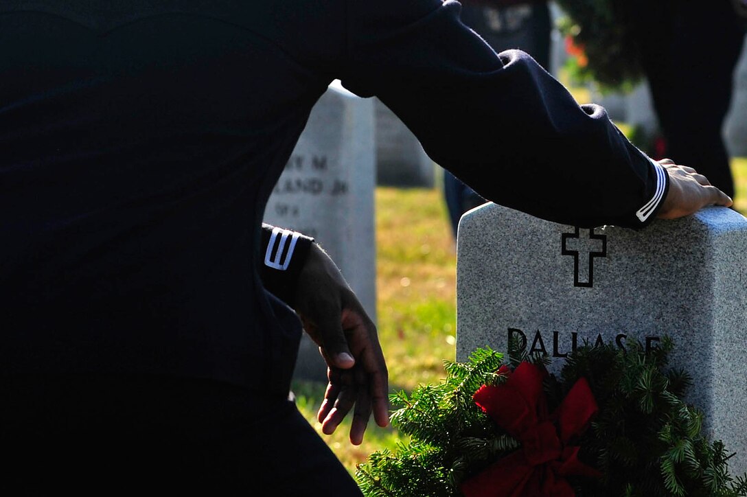A U.S. Sailor pays respects to a veteran during the annual wreath laying ceremony at the Albert G. Horton, Jr., Memorial Veterans Cemetery in Suffolk, Va., Dec. 12, 2015. U.S. Service members from all branches, the Boys and Girls Scouts of America, local JROTC and many other organizations came out to lay wreaths for the event. (U.S. Air Force photo by Senior Airman Breonna Veal)
