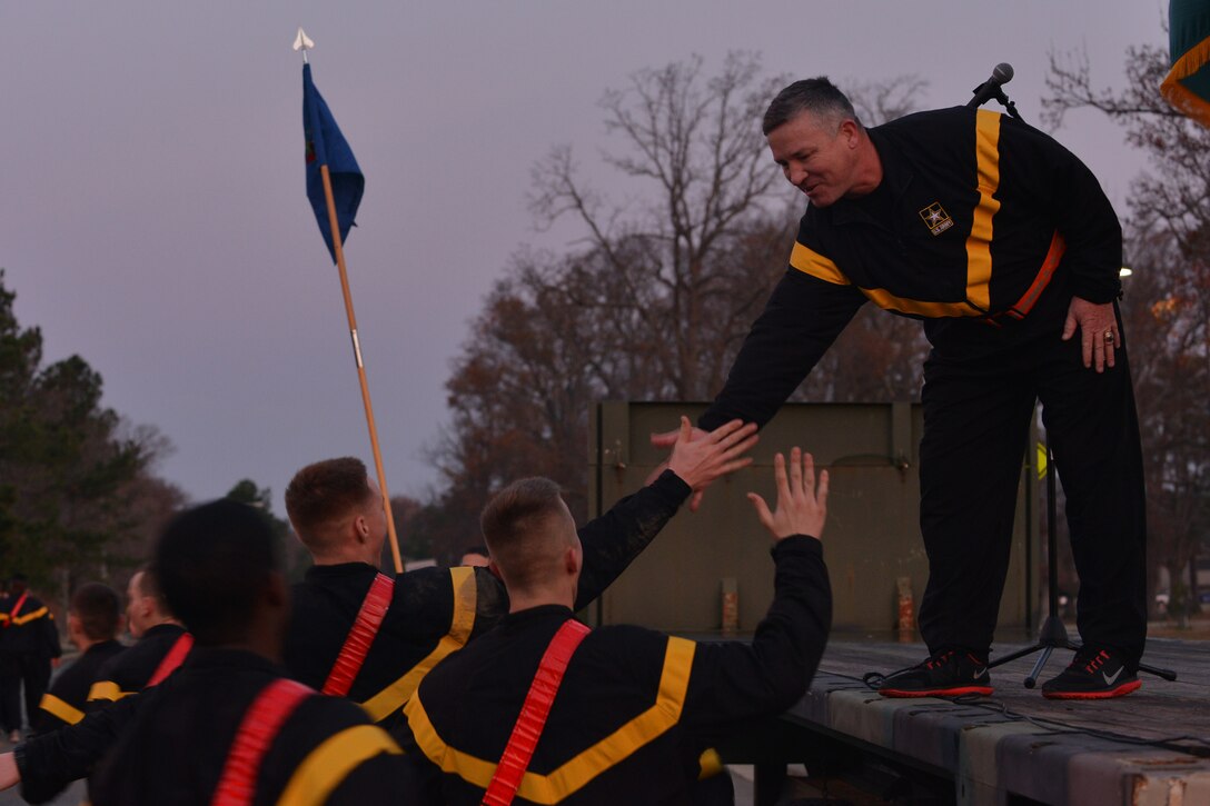 U.S. Service members run up to U.S. Army Maj. Gen. Robert M. Dyess, during the Joint Base Langley-Eustis annual holiday run, at Fort Eustis, Va., Dec. 11, 2015. Throughout the run, units ran in formations to foster teamwork and esprit de corps. (U.S. Air Force photo by Staff Sgt. Natasha Stannard)