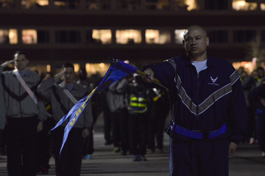 Joint Base Langley-Eustis (JBLE) Service members salute during the opening ceremonies of JBLE’s annual holiday run at Fort Eustis, Va., Dec. 11, 2015. The annual run is meant to build camaraderie while also supporting the U.S. Marine Corp’s Toys for Tots program. (U.S. Air Force photo by Staff Sgt. Natasha Stannard)
