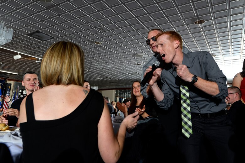 Lt. Col. Todd Benson, 2nd Space Operations Squadron commander, and Lt. Col. Timothy Purcell, 50th Operations Support Squadron commander, participate in the lip-sync competition at the 50th Space Wing Holiday Party Dec. 4, 2015, at Peterson Air Force Base, Colorado. Approximately 200 wing members, friends and families participated in the festivity. (U.S. Air Force photo/Christopher DeWitt)
