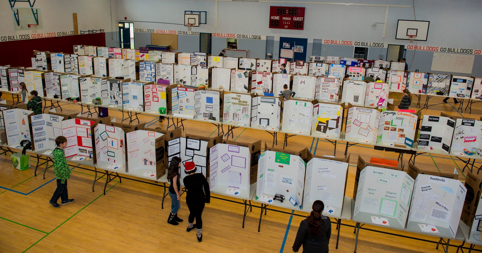Spangdahlem Middle High School students and faculty members view multiple display boards inside the SMHS gymnasium during the Invention Convention at Spangdahlem Air Base, Germany, Dec. 15, 2015. More than 100 students participated in the convention. (U.S. Air Force photo by Airman 1st Class Luke Kitterman/Released)
