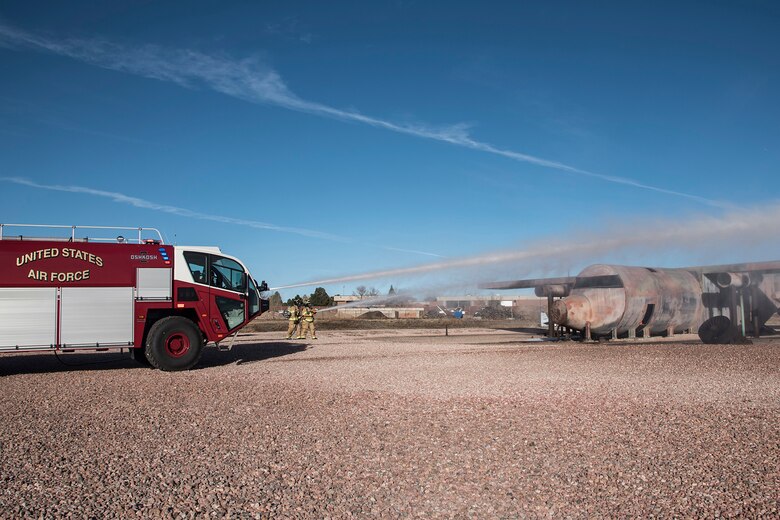 PETERSON AIR FORCE BASE, Colo. – Members of the Peterson Fire Department simulate an aircraft fire during training with the Striker 3000’s turret with firefighters using the fire hose at the same time, Dec. 8, 2015. The Striker 3000 is one of two new firefighting vehicles the FD has received in the last six months, increasing their firefighting capabilities for Team Pete, the Colorado Springs airport and the community. (U.S. Air Force photo by Senior Airman Tiffany DeNault)