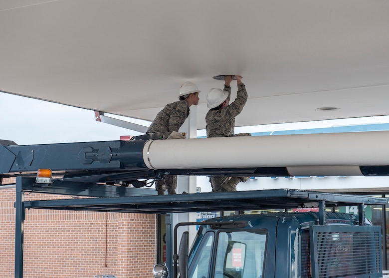 PETERSON AIR FORCE BASE, Colo. – Senior Airman Genevieve McGeary and Staff Sgt. Jason Allred, 21st Civil Engineer Squadron electricians, troubleshoot the lights on the canopy at the gas station Dec. 9, 2015. They used proper safety techniques to avoid electrical shock and then sought out the source of the inoperative light. (U.S. Air Force photo by Senior Airman Rose Gudex)