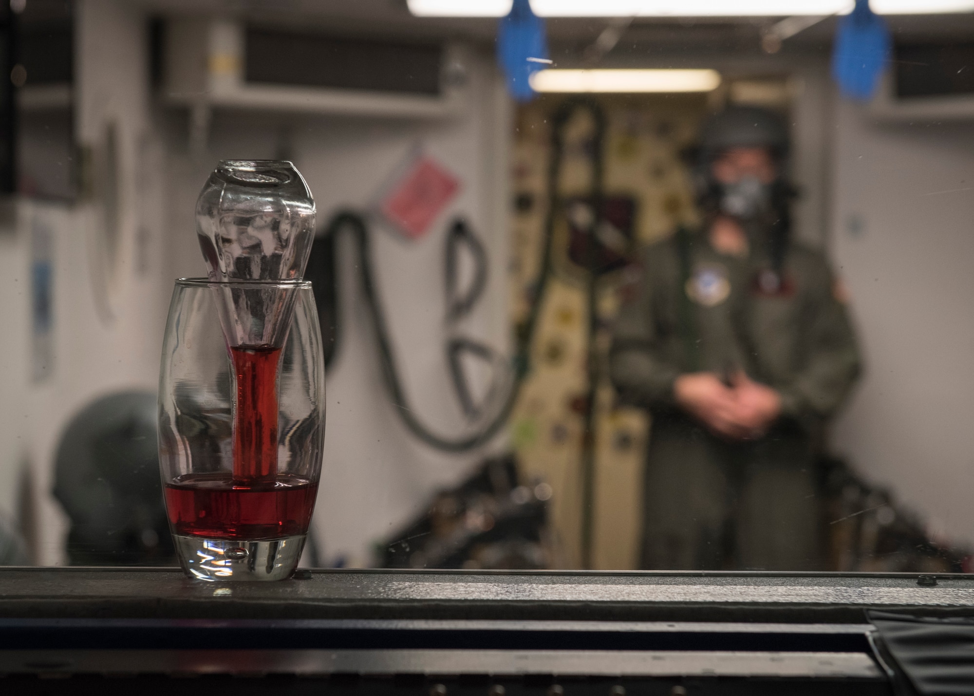 PETERSON AIR FORCE BASE, Colo. – An inverted flask and beaker sits at the edge of the high altitude chamber at the Aerospace and Operational Physiology Lab at Peterson Air Force Base on Dec. 10, 2015. During a helicopter refresher course, the students experienced the effects of low oxygen at a simulated 25,000 feet in a training environment while the flask provided a visual representation of what happens with the fluid in people’s ears if proper techniques aren’t used to equalize pressure. The chamber at Peterson AFB is one of 11 in the Air Force. (U.S. Air Force photo by Senior Airman Rose Gudex)
