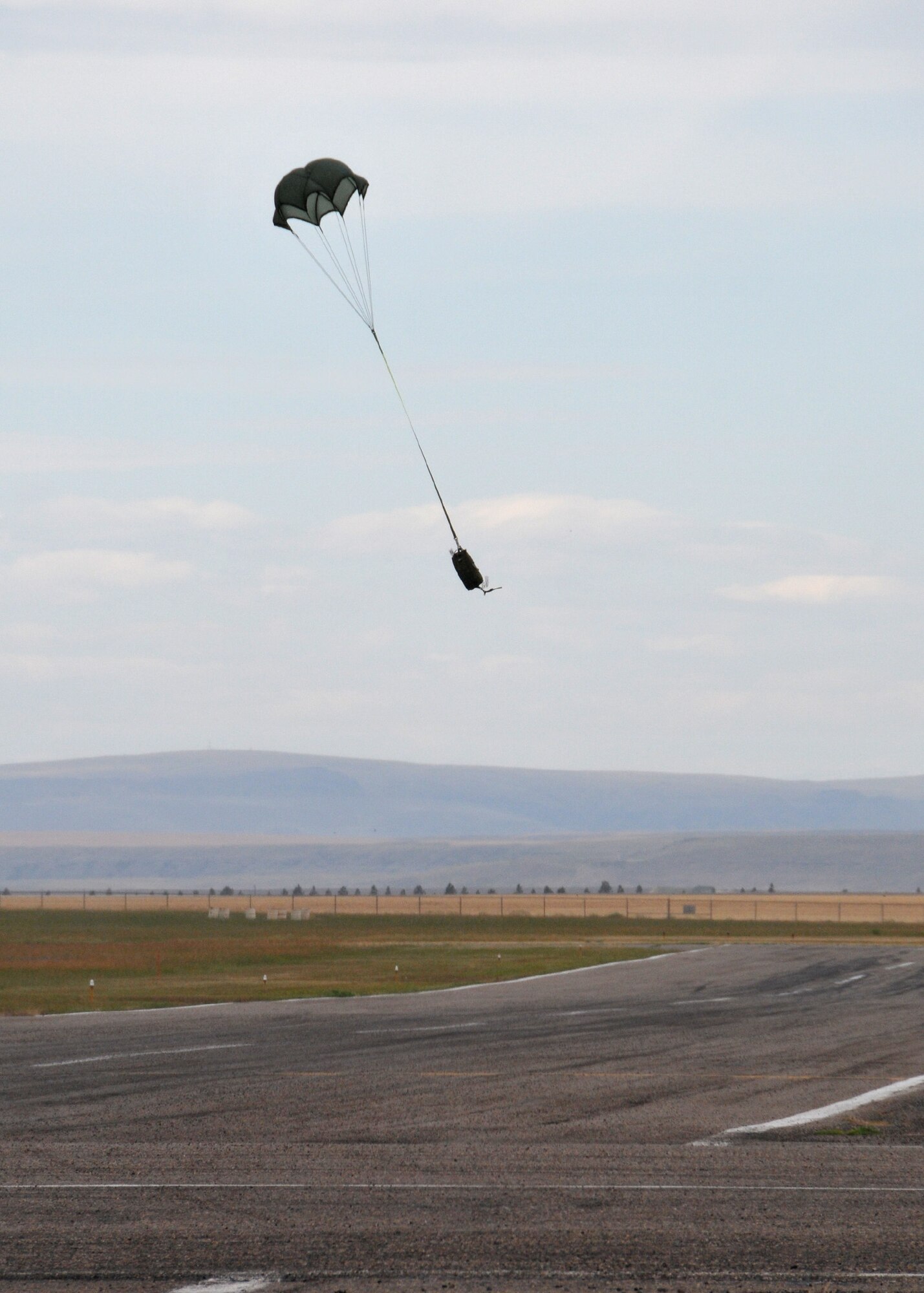 150722-Z-UJ603-089-A small sandbag connected to a parachute drops to an unused runway at the Great Falls International Airport. Air crews flying a C-130 Hercules transport aircraft assigned to the 120th Airlift Wing of the Montana Air National Guard deployed the training cargo load on July 22, 2015. (Montana Air National Guard photo/Senior Master Sgt. Eric Peterson)