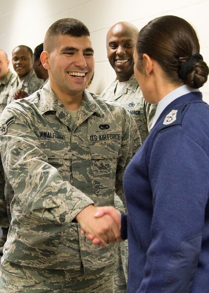Hanscom Command Chief Master Sgt. Patricia L. Hickey, congratulates Airman 1st Class Vito Amalfitano, Joint Personal Property Shipping Office Northeast storage management technician, on being selected to senior airman below-the-zone Dec 14. Below-the-zone is an opportunity for exceptionally well-qualified airman 1st class a consideration for promotion to senior airman that is six months earlier than usual. (U.S. Air Force photo by Mark Herlihy)