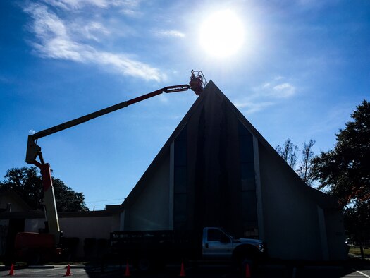 Construction workers use a lift to reach the top of the Chapel Center to replace some roofing tiles Dec. 11 at Eglin Air Force Base, Fla.  (U.S. Air Force photo/Samuel King Jr.)