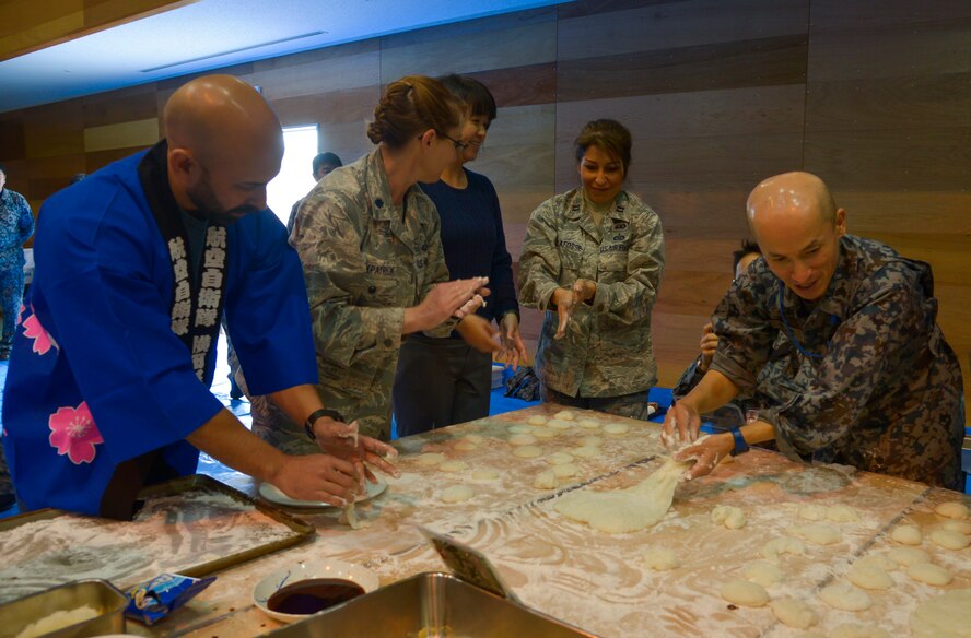Members of the U.S. Air Force and Japan Air Self-Defense Force mold pieces of mochi into different forms during a Mochitsuki ceremony at Yokota Air Base, Japan, Dec. 10, 2015. Sweets, sugars or toasted soy bean powder are often added to mochi prior to being consumed. (U.S. Air Force photo by Senior Airman David Owsianka/Released)