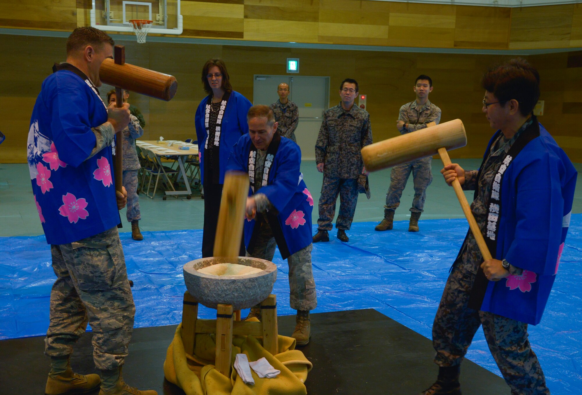 Members of the U.S. Air Force and Japan Air Self-Defense Force pound rice in a stone mortar during a Mochitsuki ceremony at Yokota Air Base, Japan, Dec. 10, 2015. After the mochi is pounded, it is broken down into smaller pieces and formed into various shapes. (U.S. Air Force photo by Senior Airman David Owsianka/Released)