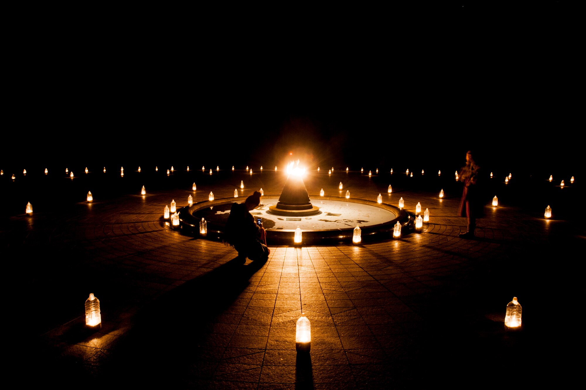Americans and Okinawans take pictures of and observe the Cornerstone of Peace at Okinawan Prefectural Peace Park, Dec. 12, 2015, in Okinawa, Japan. The lanterns were placed by volunteers, including Airmen from Kadena Air Base, as part of the Heart of Peace festival which is held yearly to commemorate the fallen of the Pacific War. (U.S. Air Force photo by Airman 1st Class Nicholas Emerick)