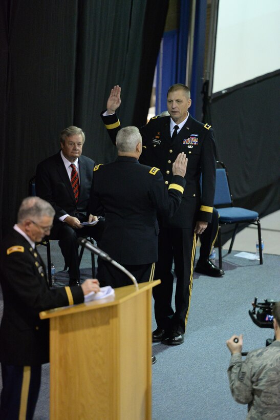 Maj. Gen. Al Dohrmann, the in-coming North Dakota adjutant general, right, takes the oath of office being administered by Gen. Frank Grass, chief of the National Guard Bureau, as North Dakota Gov. Jack Dalrymple, seated, looks on during a change of command ceremony at the Raymond J. Bohn Armory, Bismarck, North Dakota, Dec. 13, 2015. Dohrmann is assuming command from retiring Maj. Gen. David Sprynczynatyk. (U.S. Air National Guard photo by Senior Master Sgt. David H Lipp/Released)