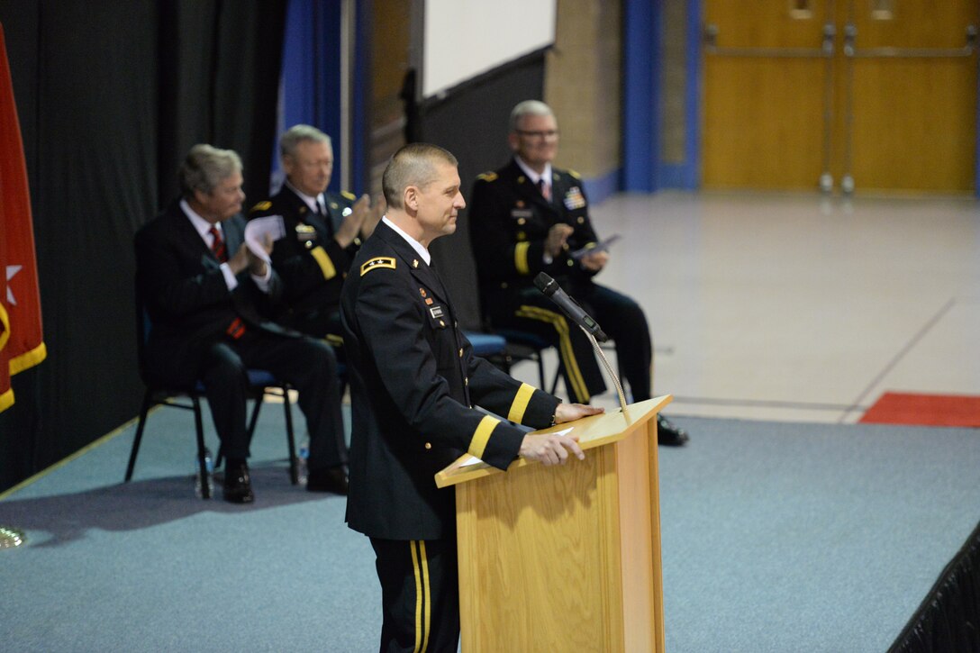 U.S. Army Maj. Gen. Al Dohrmann, the in-coming North Dakota adjutant general, foreground, speaks to an audience as North Dakota Gov. Jack Dalrymple, left, Gen. Frank Grass, chief of the National Guard Bureau, second from left, and Maj. Gen. David Sprynczynatyk, the out-going North Dakota adjutant general, far right, clap in response to comments during a change of command ceremony at the Raymond J. Bohn Armory, Bismarck, North Dakota, Dec. 13, 2015. (U.S. Air National Guard photo by Senior Master Sgt. David H Lipp/Released)