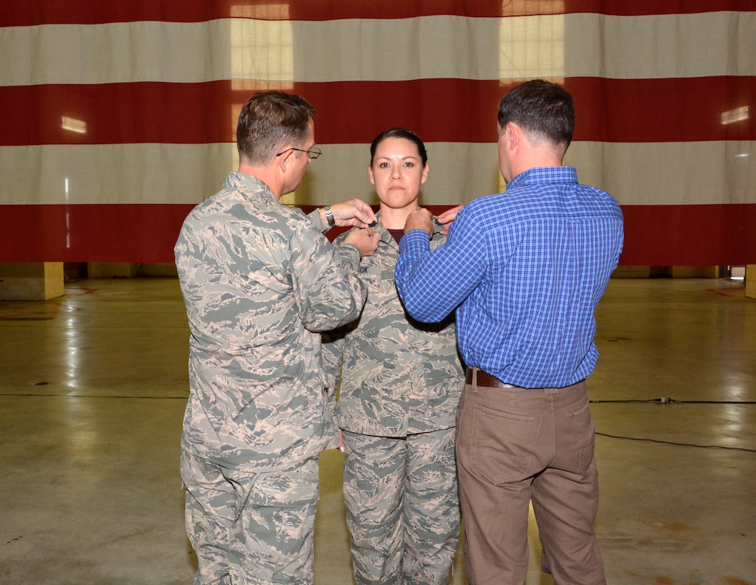 U.S. Air Force Maj. Karen Shook, commander, 145th Aircraft Maintenance Squadron is pinned to the rank of lieutenant colonel during a promotion ceremony held in her honor at the North Carolina Air National Guard Base, Charlotte Douglas International Airport, Nov. 7, 2015. Col. Stephen Mallette, commander, 145th Maintenance Group and Shook’s husband Alan, had the honor of replacing the golden oak-leaf with the silver oak-leaf, the insignia for lieutenant colonel. (U.S. Air National Guard photo by Master Sgt. Patricia F. Moran, 145th Public Affairs/Released)