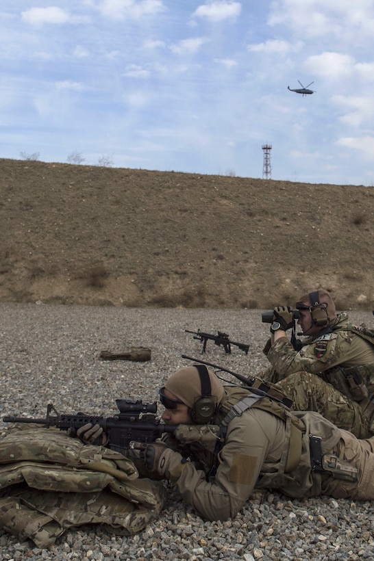 U.S. Army Staff Sgt. Justin Mark, foreground, fires an M4 rifle at a range near Kabul, Afghanistan, Dec. 8, 2015. Mark is a personal security detail member assigned to the Train, Advise, Assist Command-Air security forces. U.S. Air Force photo by Staff Sgt. Corey Hook