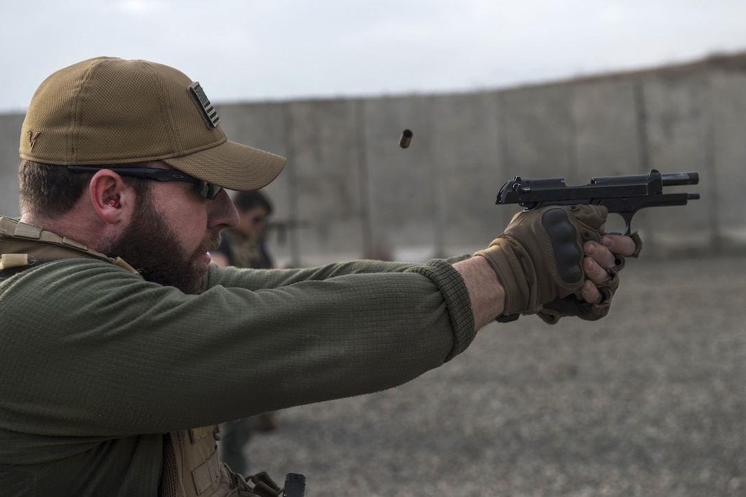 U.S. Air Force Tech. Sgt. Stephen Upton fires an M9 pistol at a range near Kabul, Afghanistan, Dec. 8, 2015. Upton is a personal security detail member assigned to the Train, Advise, Assist Command-Air security forces. U.S. Air Force photo by Staff Sgt. Corey Hook