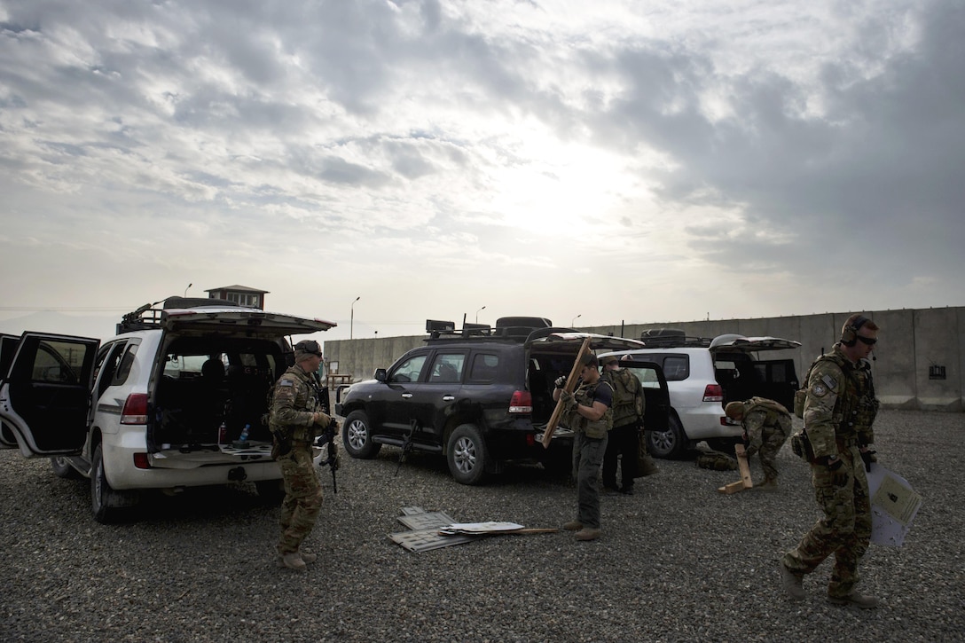 U.S. service members and personal security detail members clean up after zeroing their weapons at a range near Kabul, Afghanistan, Dec. 8, 2015. U.S. Air Force photo by Staff Sgt. Corey Hook