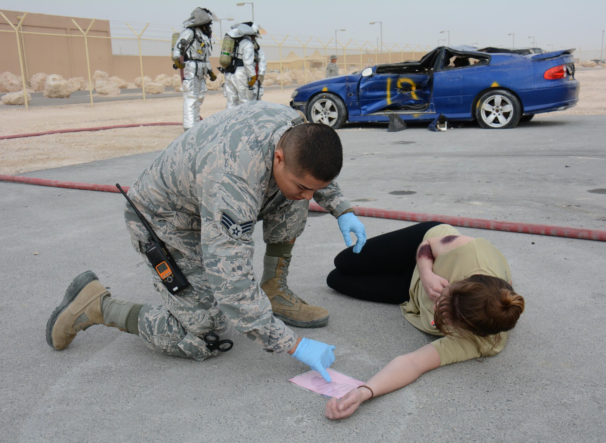 Senior Airman Marco Melendez, 379th Expeditionary Medical Operations Squadron, checks on one of eight victims of a mock car accident during a training exercise at Al Udeid Air Base, Qatar Dec. 15. More than 50 first responders participated in the exercise, including medics and firefighters. The victims of the accident were transported to the Blatchford-Preston Complex Clinic where they received emergency medical treatment. (U.S. Air Force photo by Tech. Sgt. James Hodgman/Released)