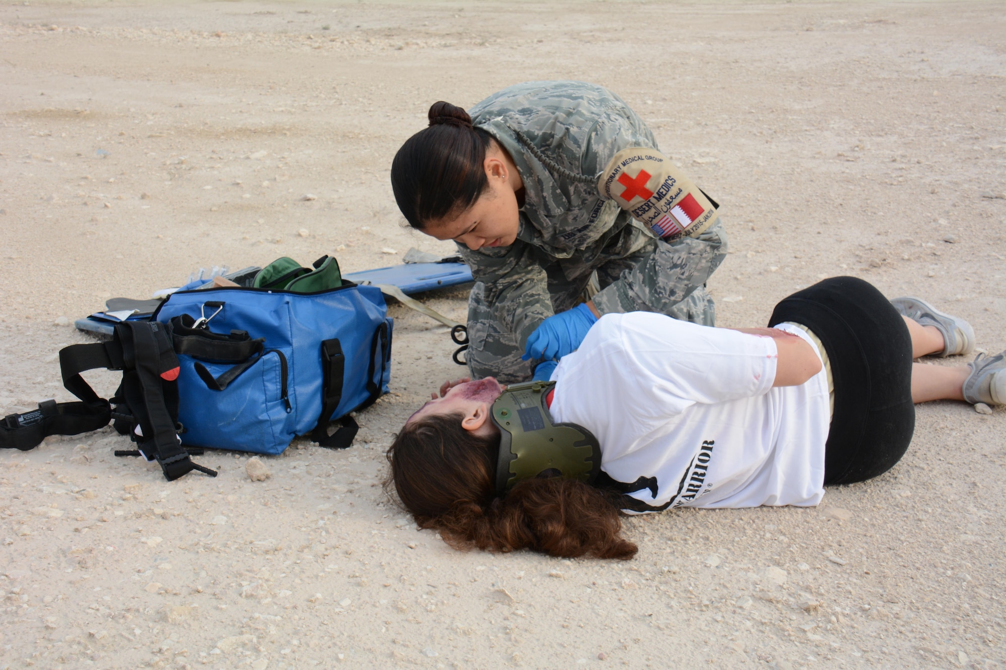 Staff Sgt. Mary Llaguno, 379th Expeditionary Medical Group, checks on one of eight victims of a mock car accident during a training exercise at Al Udeid Air Base, Qatar Dec. 15. More than 50 first responders participated in the exercise, including medics and firefighters. The victims of the accident were transported to the Blatchford-Preston Complex Clinic where they received emergency medical treatment. (U.S. Air Force photo by Tech. Sgt. James Hodgman/Released)