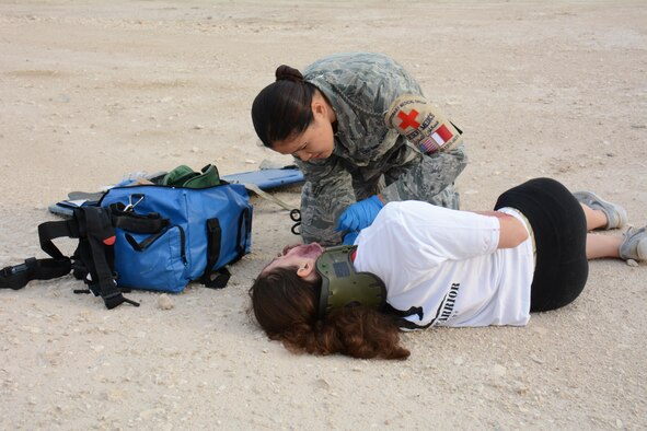 Staff Sgt. Mary Llaguno, 379th Expeditionary Medical Group, checks on one of eight victims of a mock car accident during a training exercise at Al Udeid Air Base, Qatar Dec. 15. More than 50 first responders participated in the exercise, including medics and firefighters. The victims of the accident were transported to the Blatchford-Preston Complex Clinic where they received emergency medical treatment. (U.S. Air Force photo by Tech. Sgt. James Hodgman/Released)