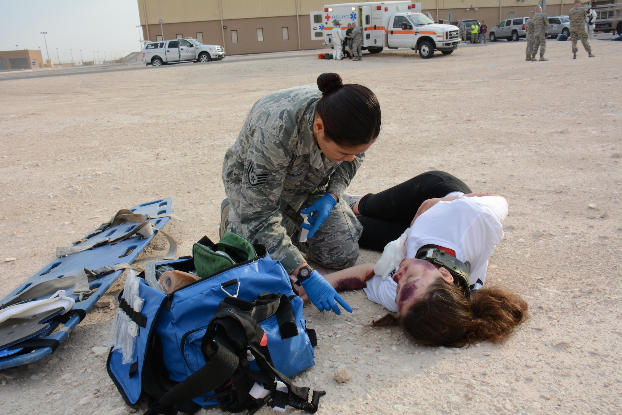 Staff Sgt. Mary Llaguno, 379th Expeditionary Medical Group, checks on one of eight victims of a mock car accident during a training exercise at Al Udeid Air Base, Qatar Dec. 15. More than 50 first responders participated in the exercise, including medics and firefighters. The victims of the accident were transported to the Blatchford-Preston Complex Clinic where they received emergency medical treatment. (U.S. Air Force photo by Tech. Sgt. James Hodgman/Released)